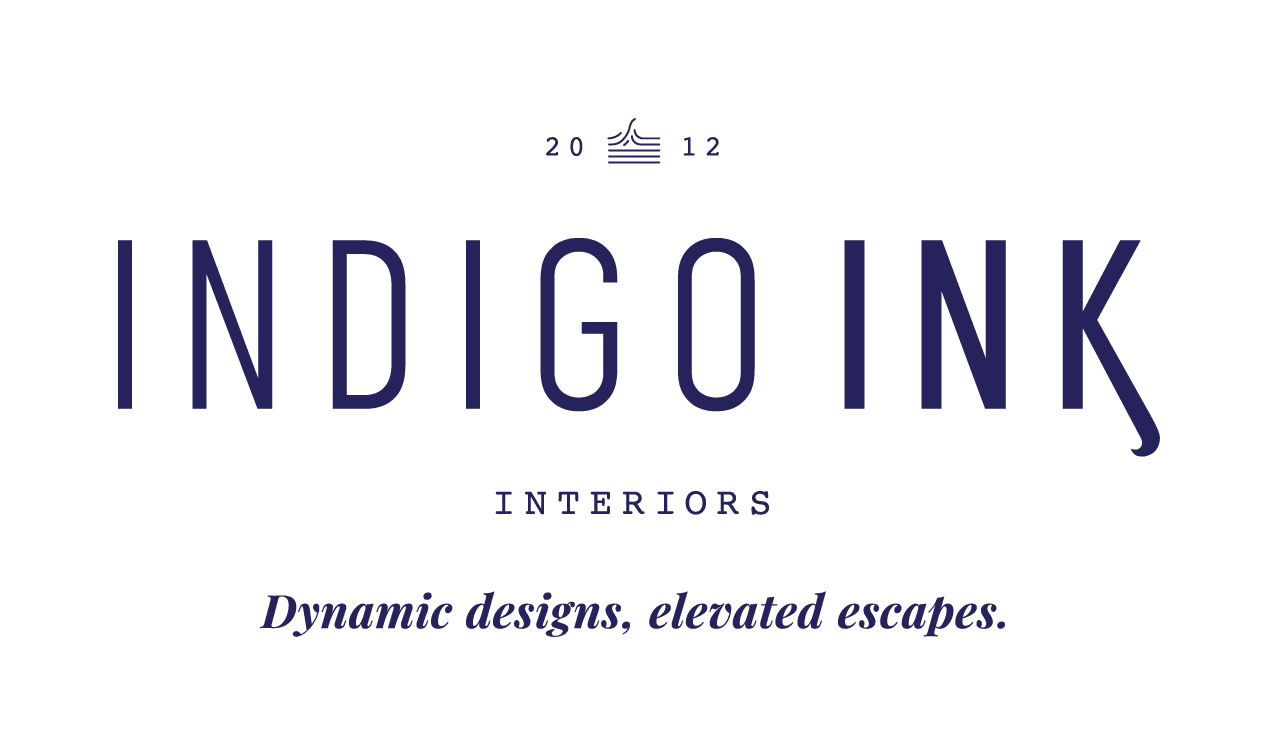 Logo for "Indigo Ink Interiors," established in 2012. The text "INDIGO INK" is in tall, modern sans-serif font with a distinctive angled leg on the letter "K." Above the name is a minimalist wave icon flanked by the numbers "20" and "12." Below, in small serif capital letters, is the word "INTERIORS," and beneath that, the tagline reads: "Dynamic designs, elevated escapes." All text is in a deep indigo blue color on a white background.
